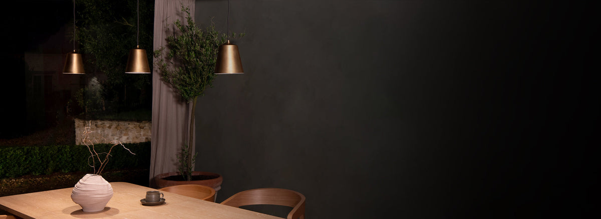 Pendant bronze light by Corston on grey background